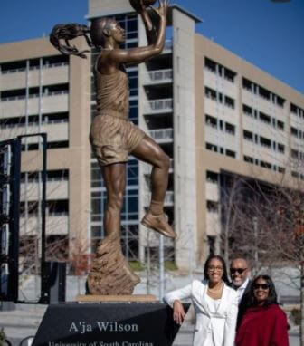 A’ja Wilson with her parents in front of her statue at university.
